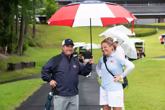 Kailin Downs and JR Steinbauer under an umbrella at Toyota Junior Golf Cup