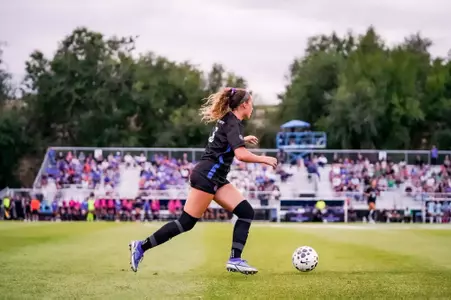Sierra McClellan, in a black jersey, goes on a run in the midfield.