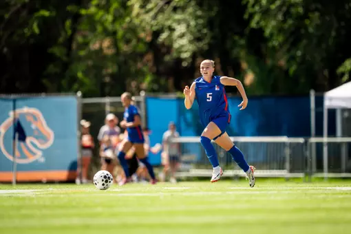 Madie Donovan, in a blue jersey, looks for a pass.