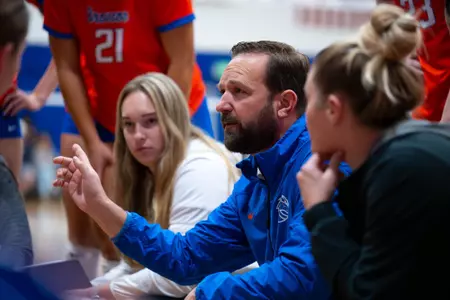 Volleyball Head Coach Shawn Garus talks to the team in a huddle during a timeout.