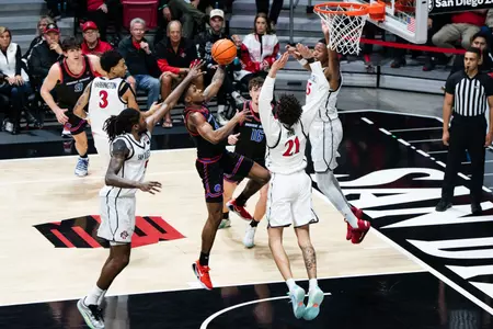Dylan Andrews attempting a layup with SDSU defenders surrounding him