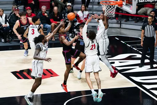 Dylan Andrews attempting a layup with SDSU defenders surrounding him