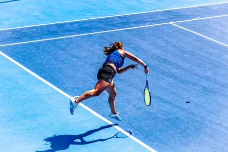 Carla Grignac following through a serve