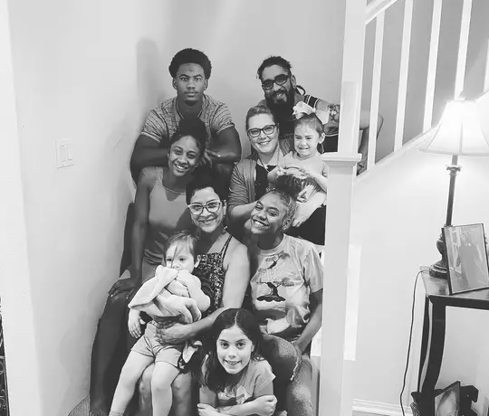 Nilka Mickey poses for a photo with her family while sitting on a staircase