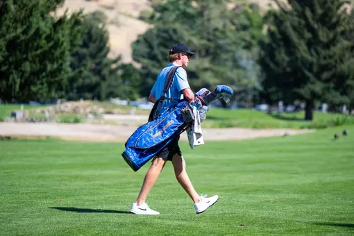 Reese Knox walking while carrying his golf bag