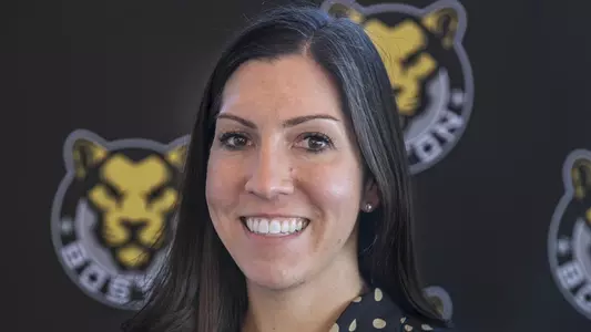 Women’s Hockey Alumna Moore ’08 posed shot with Boston Pride