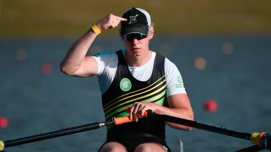 Will Legenzowski points to his Brown crew hat before preparing to row