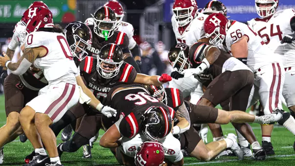 Brown's defense makes a tackle against Harvard in 2026