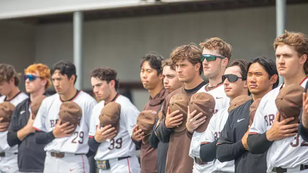 Baseball players stand for the national anthem