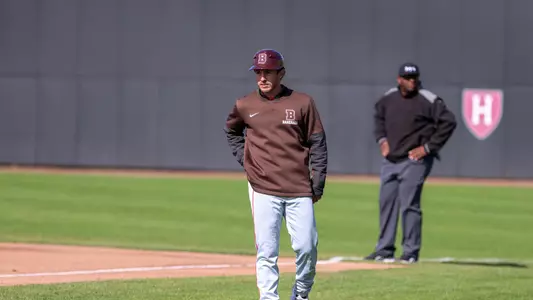 Mike Maher coaching first base at Harvard, April 2026