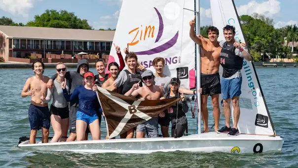 The Brown open sailing team posts with the team flag after winning the College Sailing Open Fleet Race National Championship