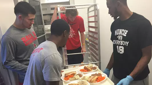Men's Basketball Volunteers by Serving Meal