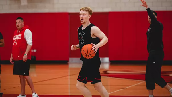 Aaron Fine in a black practice uniform dribbling a basketball