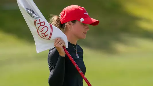 Taylor Larkins holds the flag during one of her rounds at the Golfweek Red Sky Classic