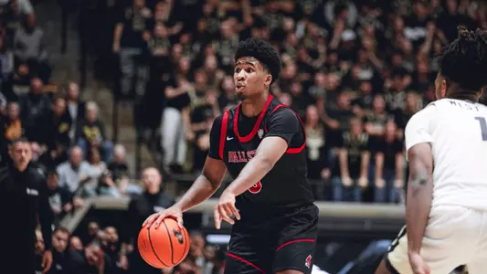 Sean Blake in a black Ball State basketball uniform dribbling