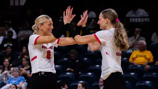 Merritt Sliwa and Tiffany Snook high five during a match at Toledo.