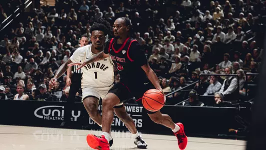 K'Jei Parker in a black Ball State men's basketball uniform dribbling the ball