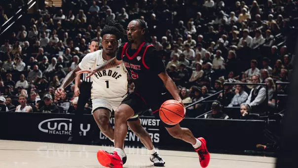 K'Jei Parker in a black Ball State men's basketball uniform dribbling the ball