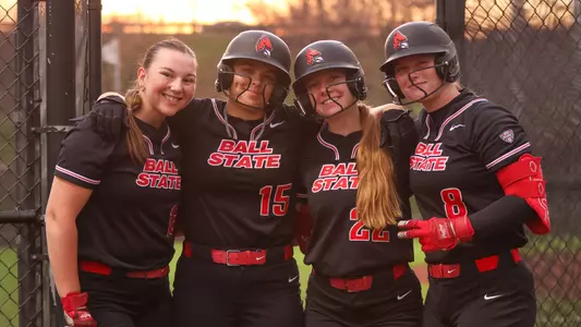 Softball poses in batting cages before Cardinal Classic