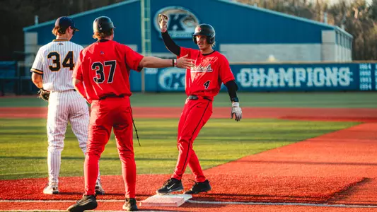 Gavin Balius giving Luke Jaksich a high five after reaching first base safely on Friday night at Schoonover Stadium in Kent, Ohio.