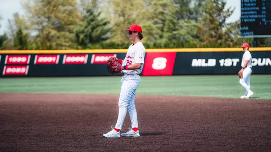 Jack Bakus in a white Ball State baseball uniform playing first base.