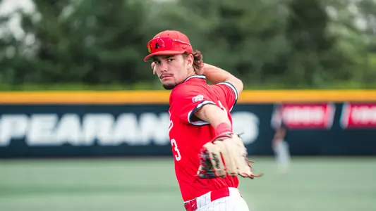 Brett Griffiths in a red Ball State baseball throwing a ball in a Friday afternoon game vs UMass