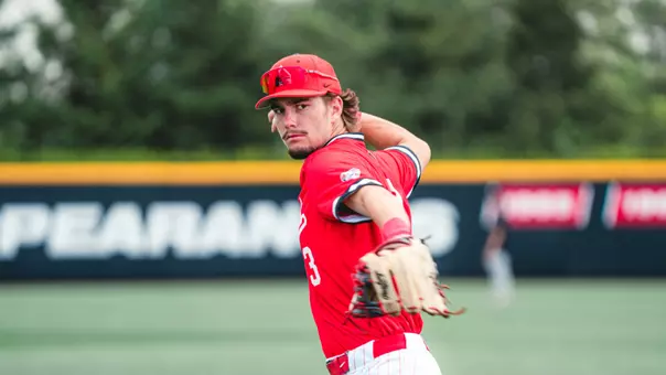 Brett Griffiths in a red Ball State baseball throwing a ball in a Friday afternoon game vs UMass