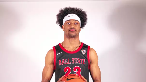 Kai McGrew wearing a white headband and black Ball State basketball uniform