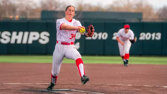 Bridie Murphy pitching in her white pinstripe uniform at the Ball State Softball Stadium