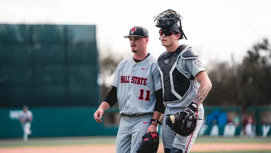 Luke Reed and DJ Scheumann in grey Ball State baseball uniforms walking off the field