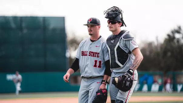 Luke Reed and DJ Scheumann in grey Ball State baseball uniforms walking off the field