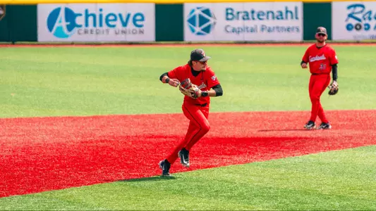 Brett Griffiths in a red Ball State baseball uniform fielding a ball