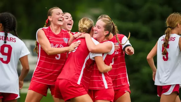 Anna Kate Robillard in a red Ball State soccer uniform celebrates with teammates after scoring a goal in a match against IU Indy