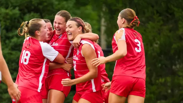 Ball State soccer players in red uniforms celebrate a goal