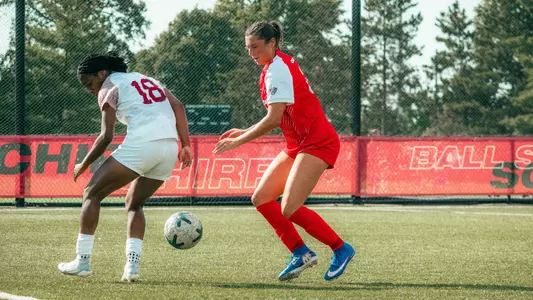 Jordyn Klaasen in a red Ball State soccer uniform fighting for possession of the ball