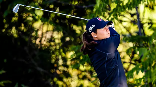 Lexi Ray taking an iron shot with trees in the background at the Brittany Kelly Classic