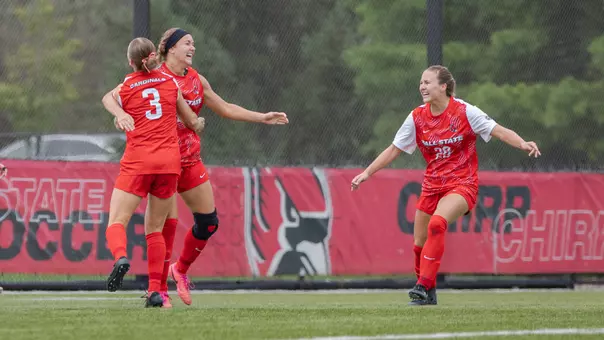 Ball State players in red uniforms celebrate a goal