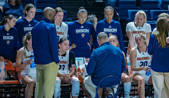 WBB bench huddle with coaches