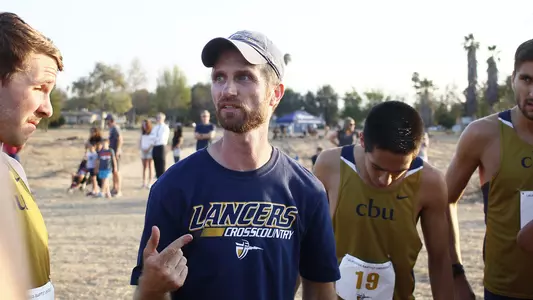 Coach Dr. Ben Gall talks to his men's cross country team.