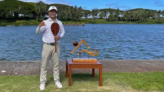 Aaron Du Holds Individual Medalist Trophy at John Burns Intercollegiate