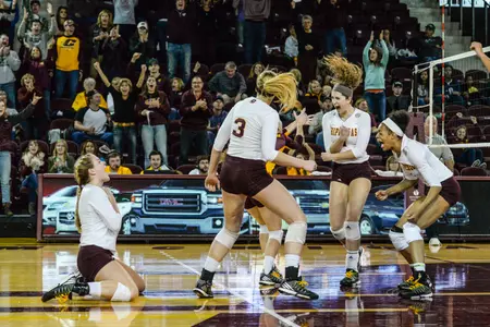 CMU players celebrate match point Saturday in a five-set Mid-American Conference victory over Ohio at McGuirk Arena.