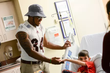 Central Michigan running back Romello Ross talks with a patient on Sunday at the Baptist Children's Hospital in Miami.