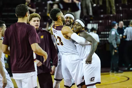Marcus Keene (center) and Braylon Rayson (right) get a congratulatory hug from teammate DaRohn Scott on Tuesday after the pair combined for 70 points in CMU's 107-97 win over Green Bay.