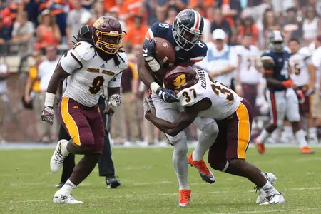 CMU's Otis Kearney (37) hits a Virginia receiver Saturday in the Chippewas' 49-35 loss. At left is linebacker Malik Fountain.