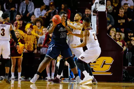 CMU's DaRohn Scott (center) and Cecil Williams (right) battle Akron's Isaiah Johnson on Tuesday at McGuirk Arena.
