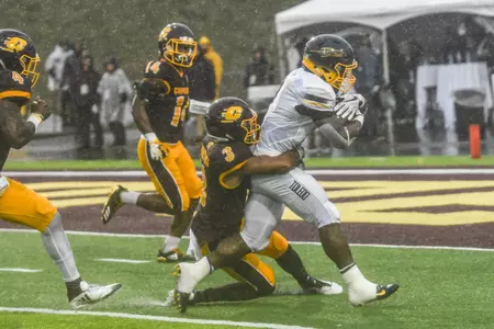 CMU cornerback Sean Bunting (left) drags down a Toledo ballcarrier on Saturday at Kelly/Shorts Stadium.