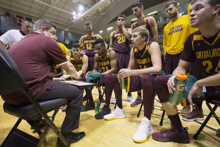 CMU coach Keno Davis (left) talks with his players during a timeout on Saturday night during the championship game of the Great Alaska Shootout.