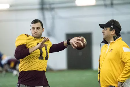 CMU quarterback Shane Morris throws a pass in practice Tuesday under the watchful eye of offensive coordinator/quarterbacks coach Chris Ostrowsky.