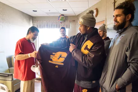 CMU seniors present a Chippewa t-shirt to a patient at Boise Veterans Administration Medical Center on Thursday. The Chippewas are set to play Wyoming on Friday in the Famous Idaho Potato Bowl (4 p.m. EST, ESPN).