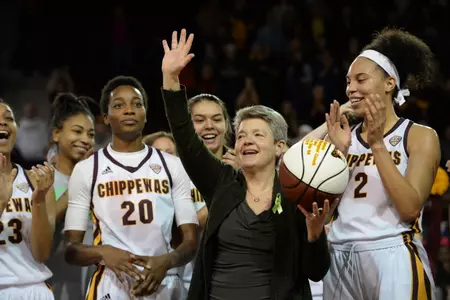 CMU coach Sue Guevara salutes the cheering crowd earlier this season after receiving a ball commemorating her record 172nd win at CMU. Guevara and the Chippewas are on the verge of claiming the program's first overall MAC regular-season championship since 1985.